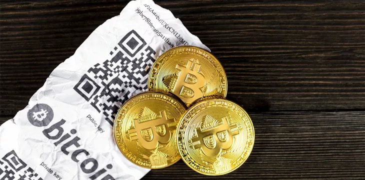 Bitcoin golden coins and paper receipt isolated on a black wood background