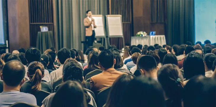 Man speaking in front of many people