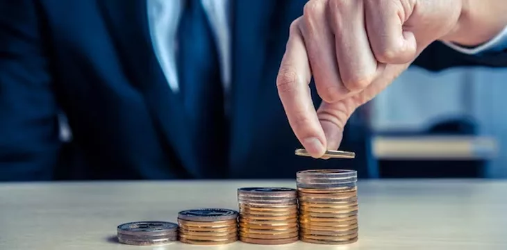 businessman stacking gold and silver coins