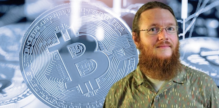 Photo of George Maxwell against a bitcoin background