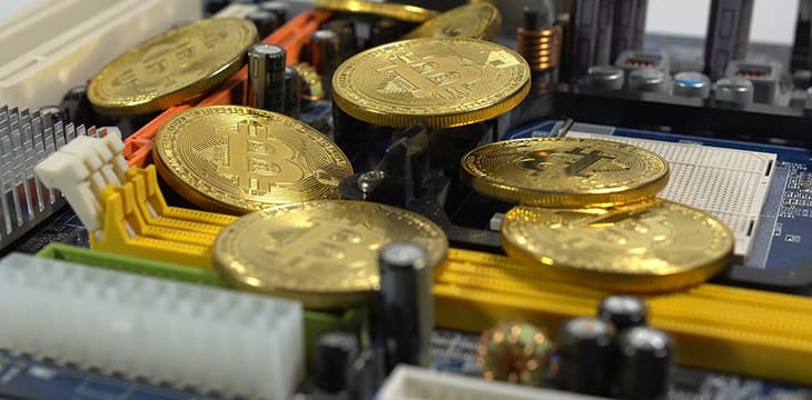 Gold coins over a computer component symbolizing crypto currency usage