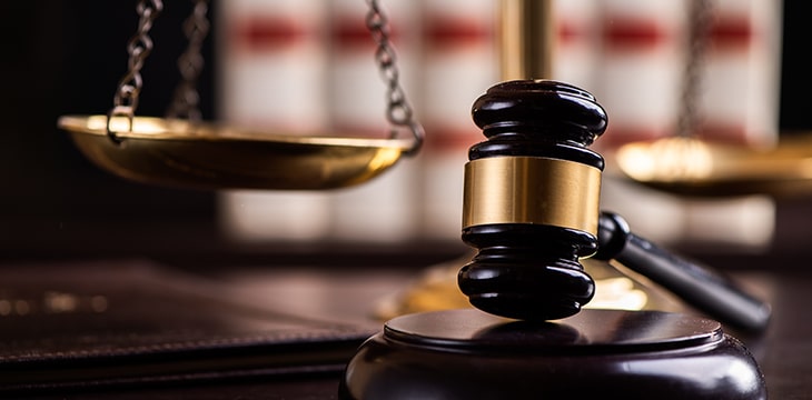 Judge gavel, scales of justice and law books in court close up