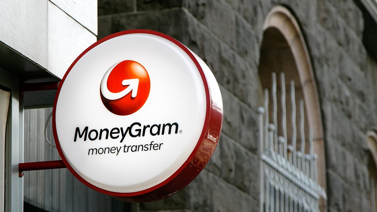 MoneyGram sign is mounted to a wall above the entrance to their branch