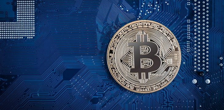 Golden Bitcoin on a blue computer chip background