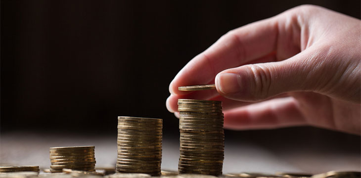 Hand putting coins on a stack