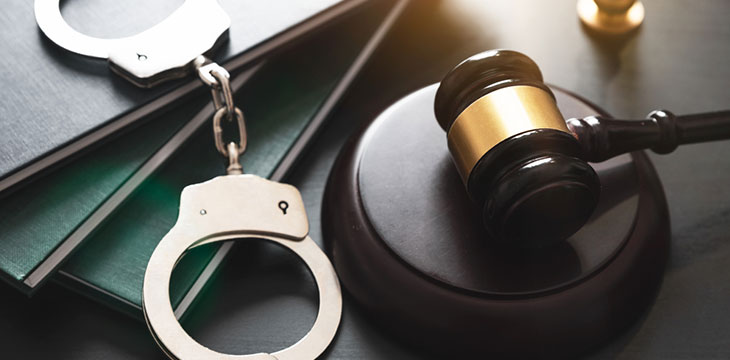 Handcuff and gavel on table