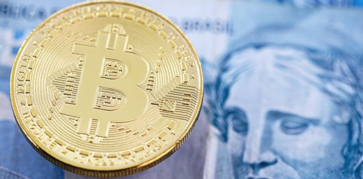 Electronic bitcoin coins, with a hundred dollar bill in the background.