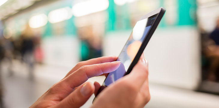 Woman using her cell phone on subway platform