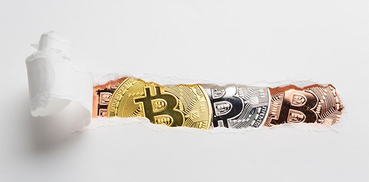 Ripped paper revealing bitcoin