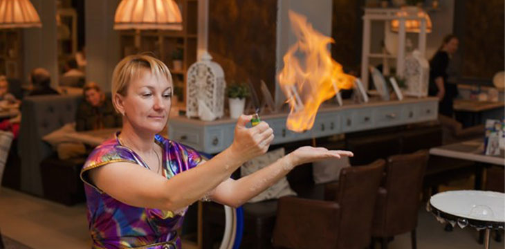 A lady doing fire trick on her palm