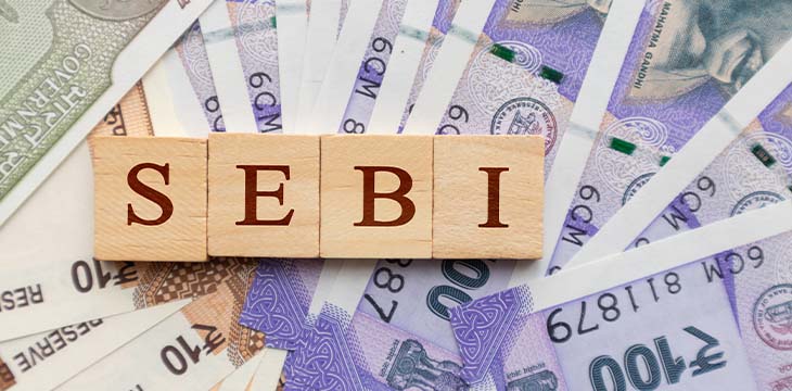 SEBI in wooden block letters on Indian Currency