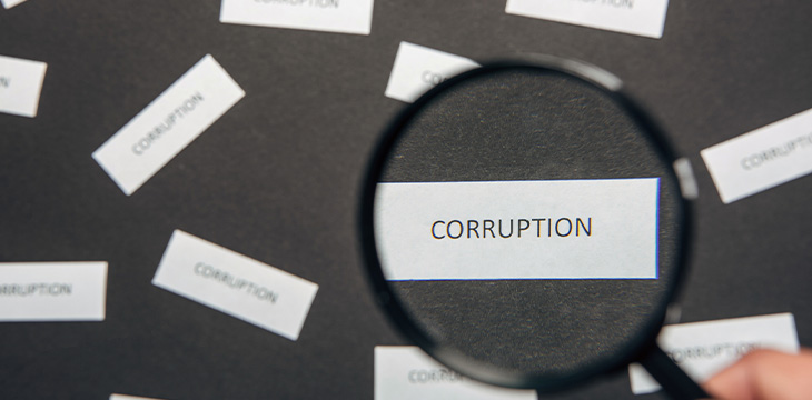 Magnifying a piece of paper with "corruption" written