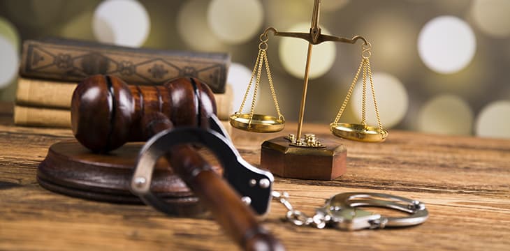 Golden scales of justice, books and a gavel on a table.