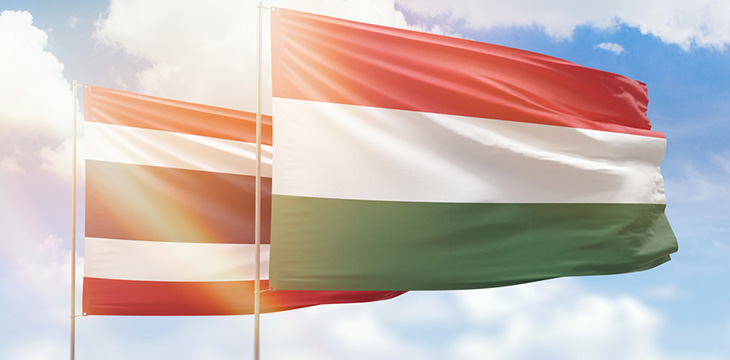 Sunny blue sky and flags of hungary and thailand