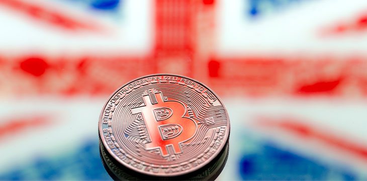 Coins Bitcoin, on a background of Great Britain and the British flag