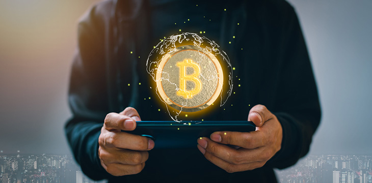 A person holding a tablet with an illustration of trading cryptocurrency coins