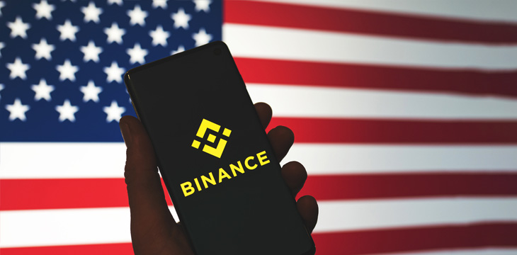 Binance icon on phone with the US flag background