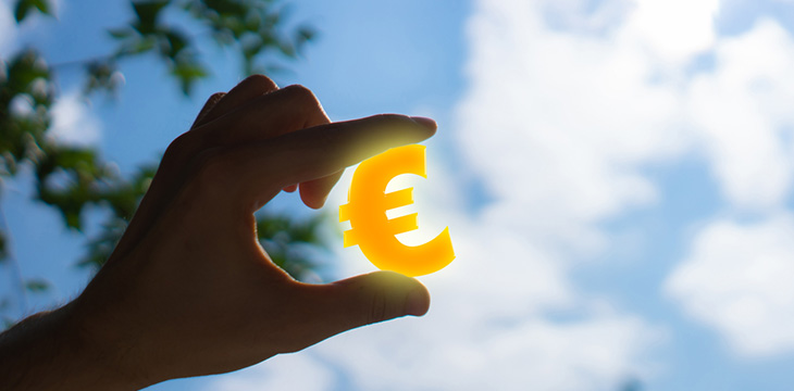 hand holding a gold euro sign