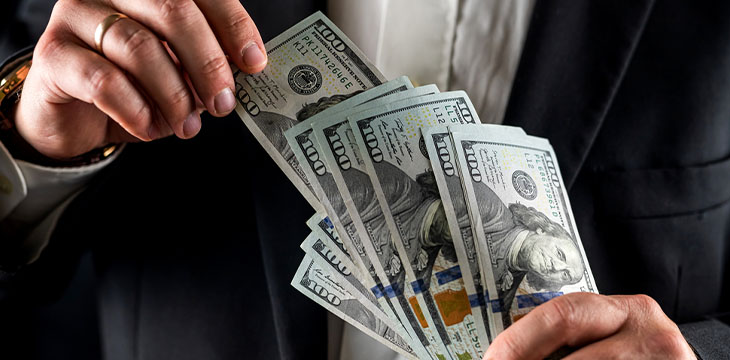 businessman counting 100 dollar bills