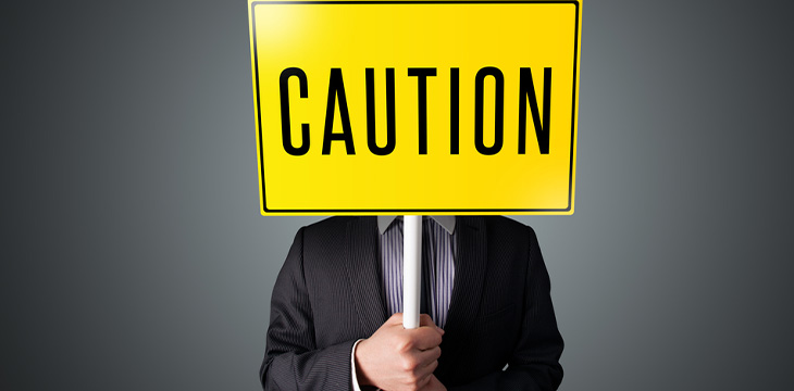 businessman raising a caution sign