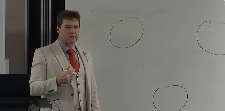 Dr. Craig Wright at the Bitcoin Masterclass standing next to whiteboard