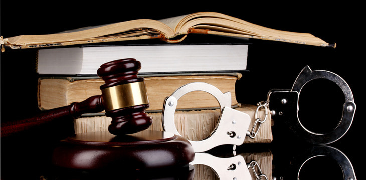 Gavel, handcuffs and books on law isolated on black background