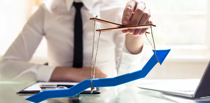 Businessperson's Hand Manipulating Blue Arrow With Rope