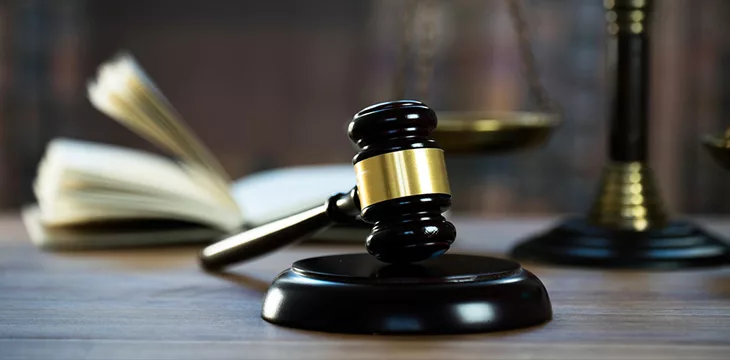 Judge's wooden gavel with blurred background of open book