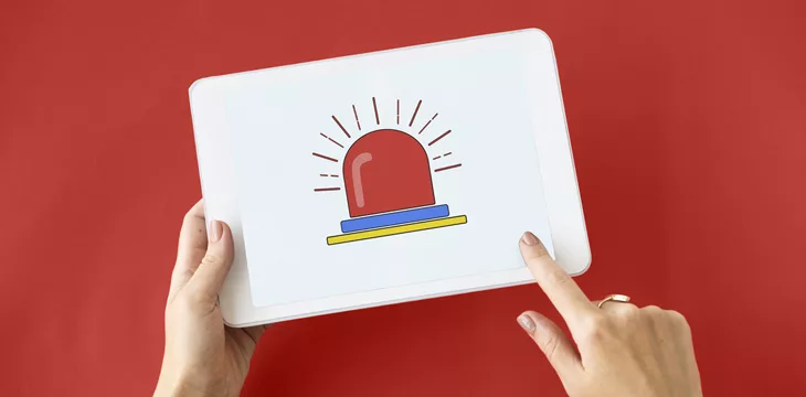 Person holding digital tablet with red background