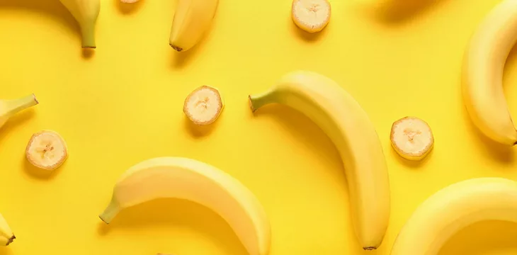 Ripe bananas on yellow background