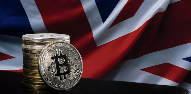 Stack of bitcoins over flag of United Kingdom