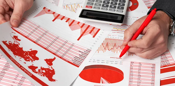 Businessman accountant using calculator for calculating crypto currency report on desk office