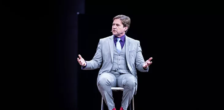 Dr. Craig S. Wright seated with dark background