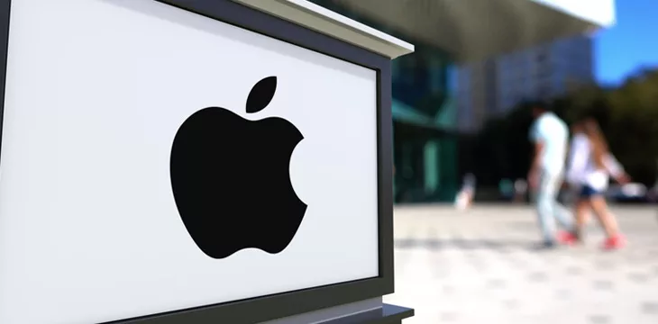 Street signage board with Apple Inc. logo. Blurred office center and walking people background.