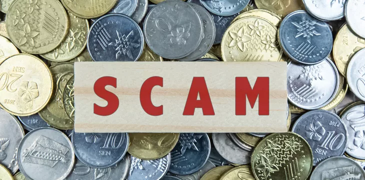 Wooden Blocks with the text "scam" with coin background