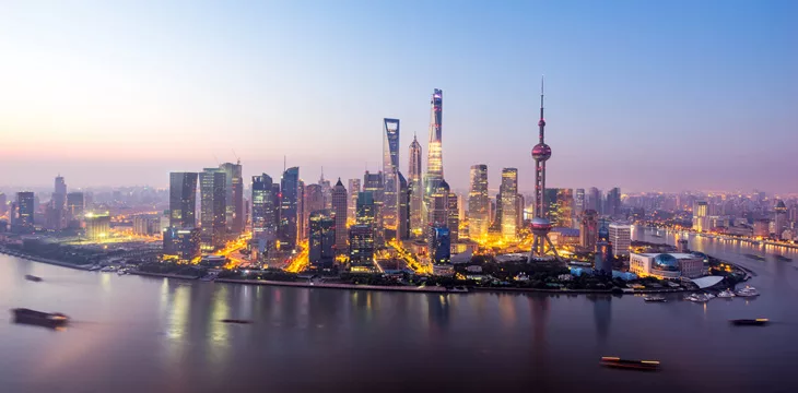 Skyscrapers of the city in China around a river at dusk