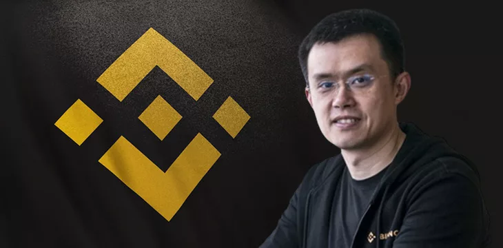 Changpeng Zhao in front of Binance logo