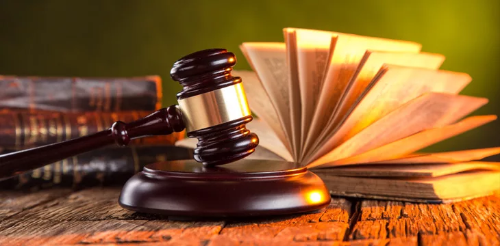 Wooden gavel and books on wooden table