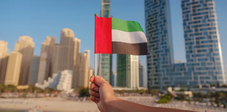 Close up of a female hand holding tiny flag of UA