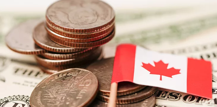 Canada flag with coins on dollar banknotes