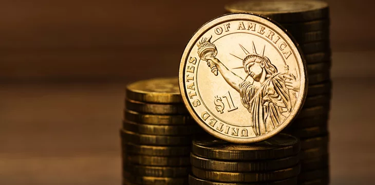 One dollar coin and money on desk in stack