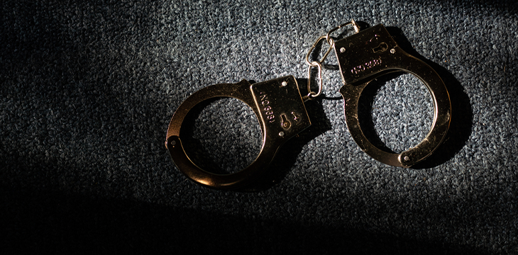 black handcuffs on wooden background